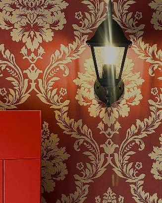 A black lantern lamp on red and gold damask wallpaper inside The Síbín